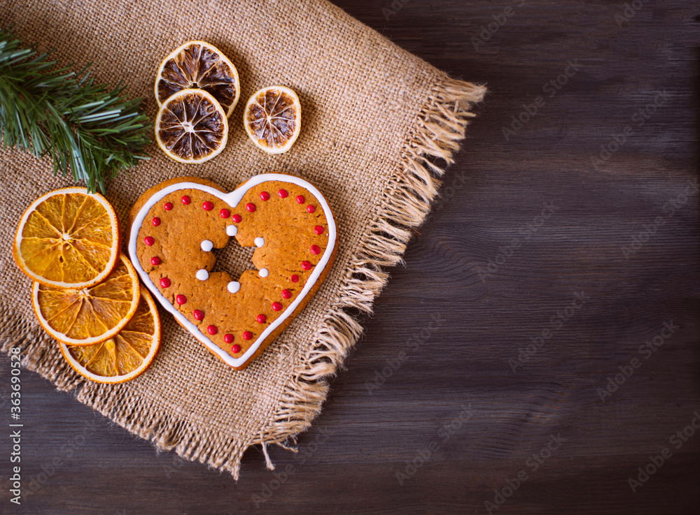 Christmas tasty cookies lie on a napkin on a wooden background. Around the cookies lies dried orange and a spruce branch. Christmas tasty cookies lie on a napkin on a wooden background. Around the cookies lies dried orange and a spruce branch.