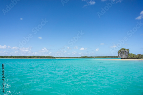 Beautiful seascape of Upi Bay, Pines Island, new caledonia: turquoise lagoon, lush vegetation, blue sky. © mathilde