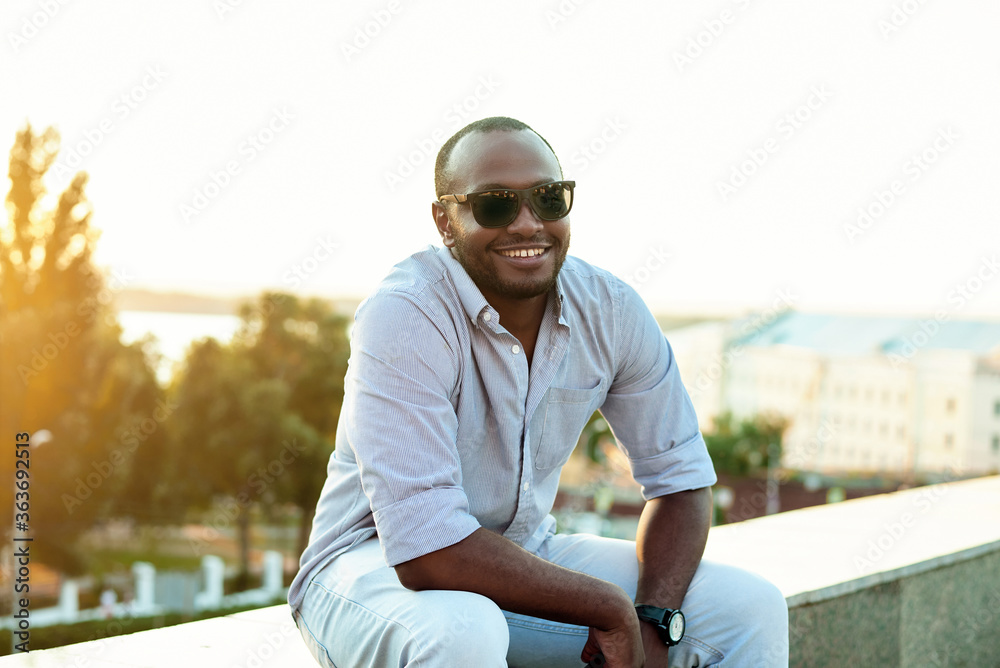 Portrait of a smiling cheerful black man on a sunny day against the background of the city Portrait of a smiling cheerful black man on a sunny day against the background of the city
