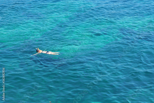 Girl swims in a diving mask . Scooba in turquoise colored water 