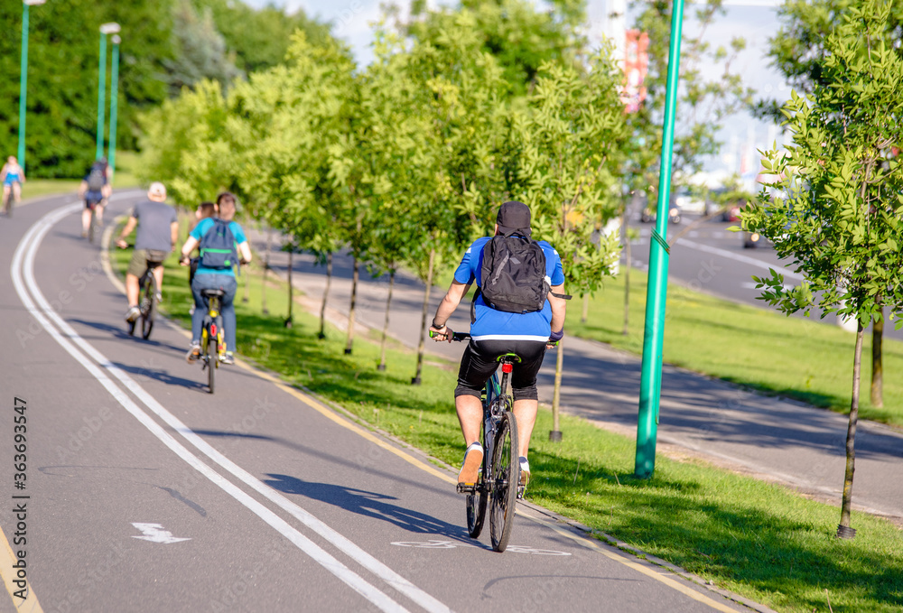 Fototapeta premium Cyclists ride on the bike path in the city Park 