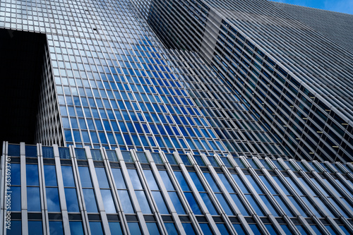 Business background. Skyscraper with blue sky reflections on the glass
