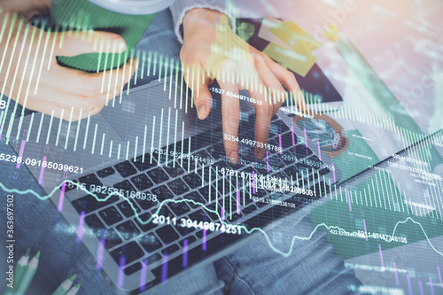 Double exposure of woman hands typing on computer and forex chart hologram drawing. Stock market invest concept.