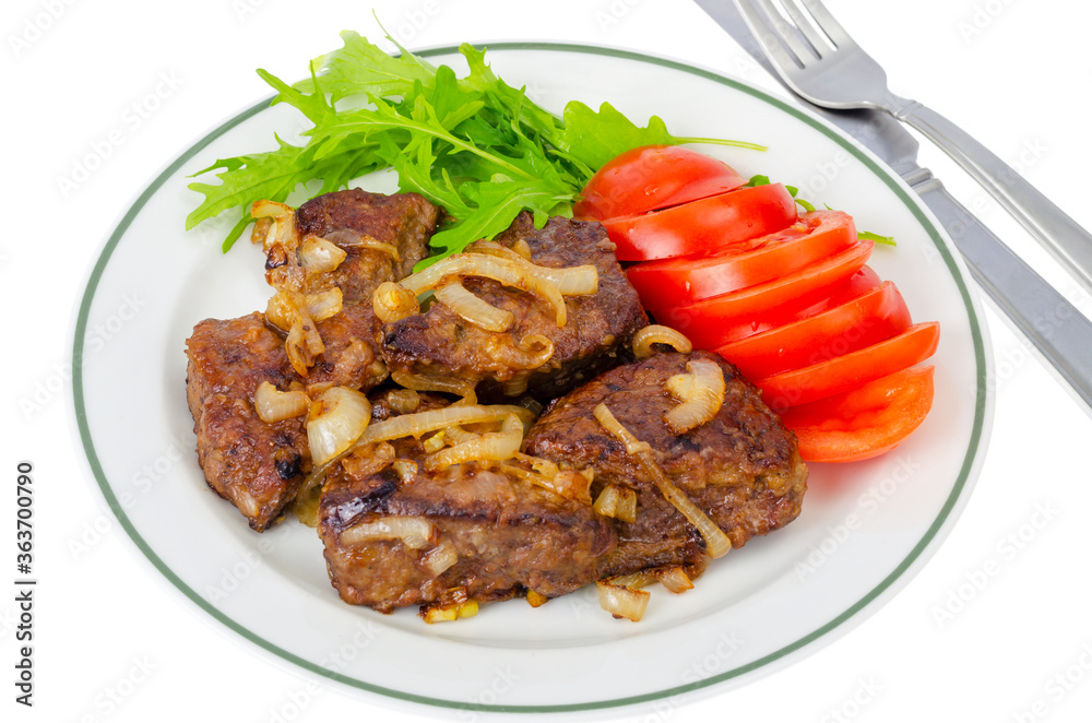 Pieces of fried liver with onions, fresh leaves of salads