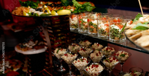 Cuadro en lienzo Catering. Glasses with salads and snacks on glass shelves.