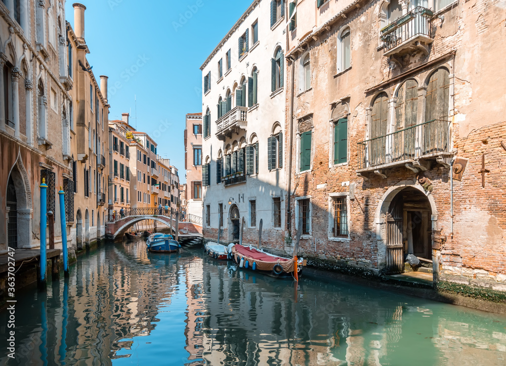 Scenic View of Venetian Canal with Boats under Blue Sky in Venice, Italy