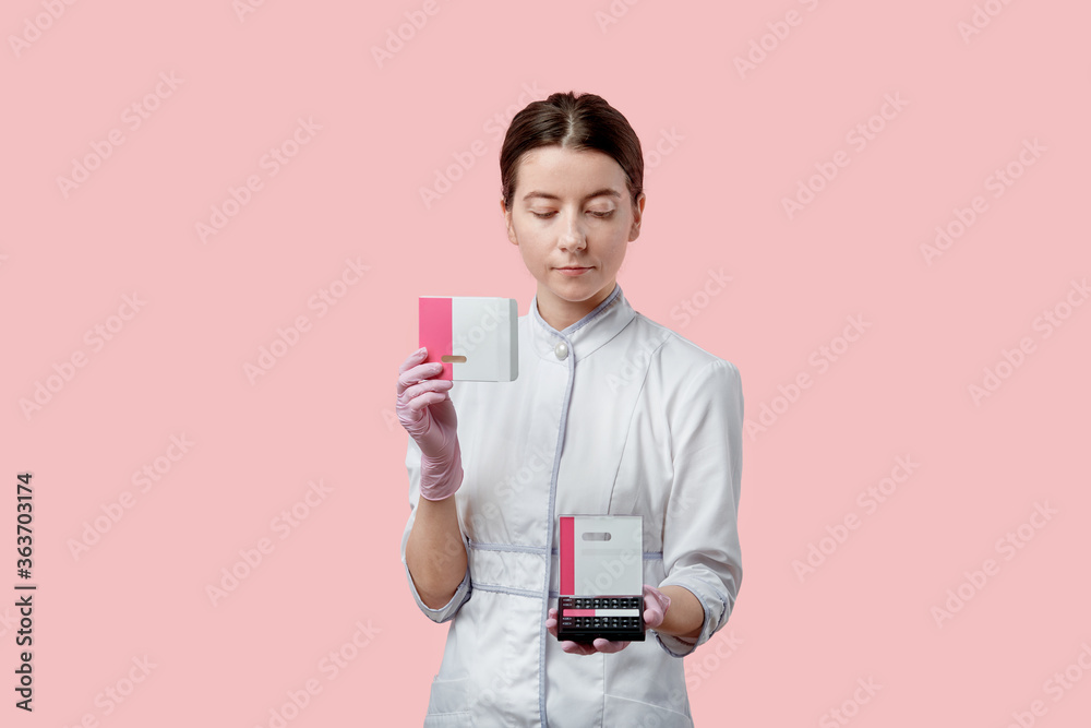 The young woman opened a small pink box with braces. Hands in medical gloves. The young woman opened a small pink box with braces. Hands in medical gloves.