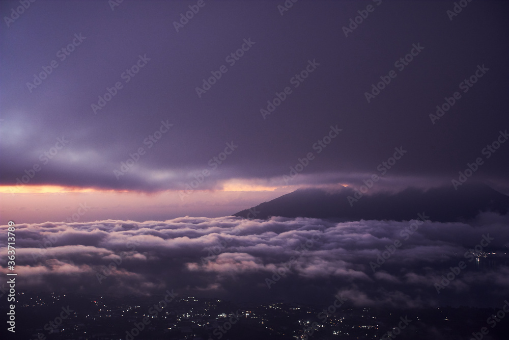   Bali indonesian island from the top of Batur mountain at the night time with night star sky and city lights at the bottom