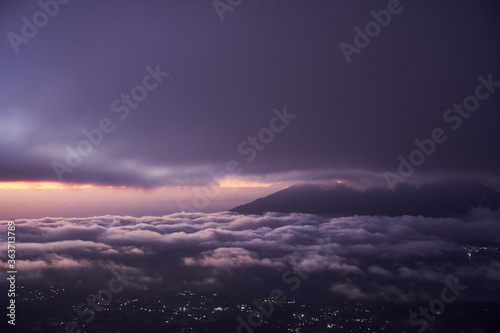  Bali indonesian island from the top of Batur mountain at the night time with night star sky and city lights at the bottom