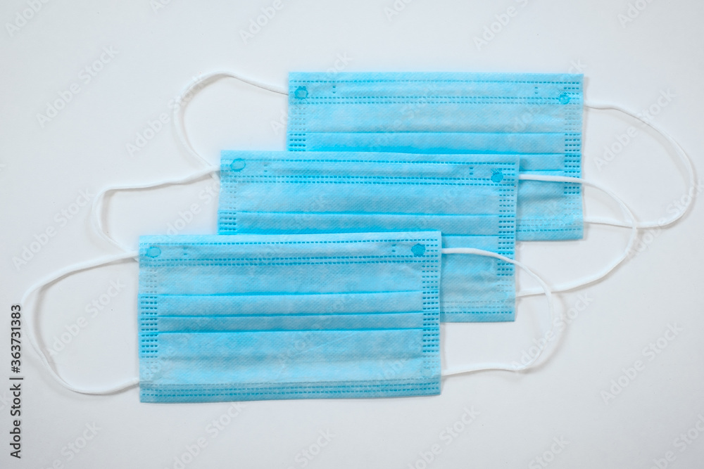Three isolated light blue ear loop masks from top view Three isolated light blue ear loop masks from top view