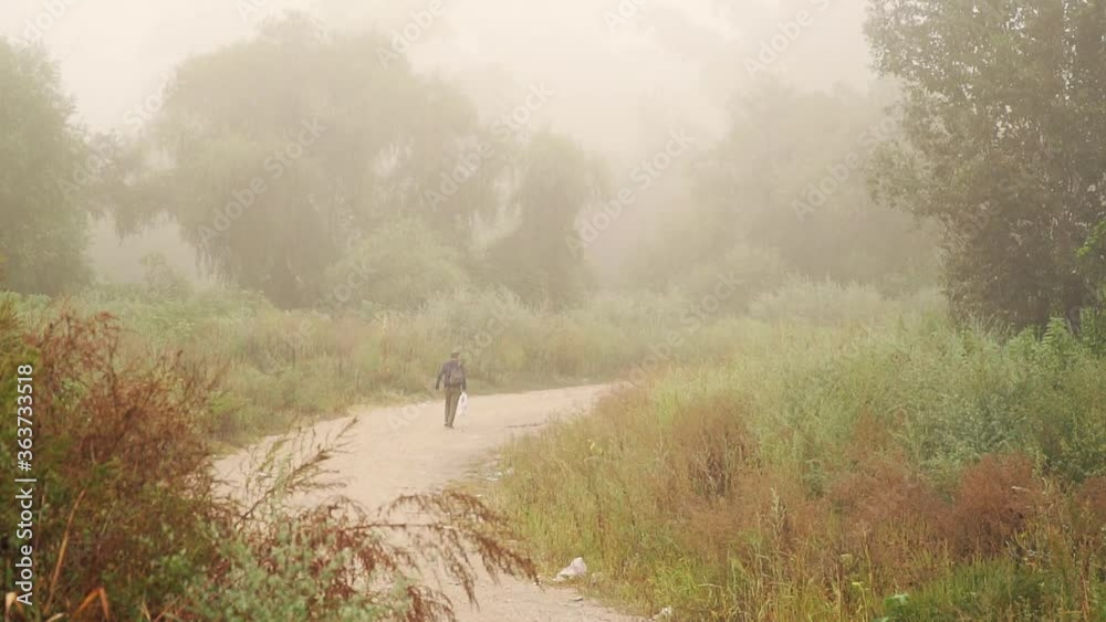 Man walking trough the forest on a country road Man walking trough the forest on a country road
