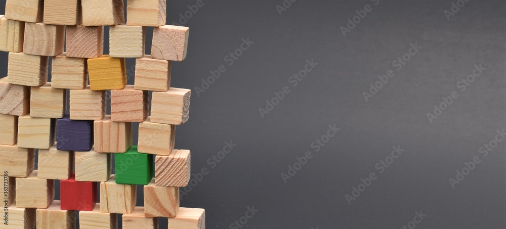 Pile of multicolored wooden blocks on black background. Shows diversity in the workplace, building together as a team of individuals. Room for copy. Pile of multicolored wooden blocks on black background. Shows diversity in the workplace, building together as a team of individuals. Room for copy.
