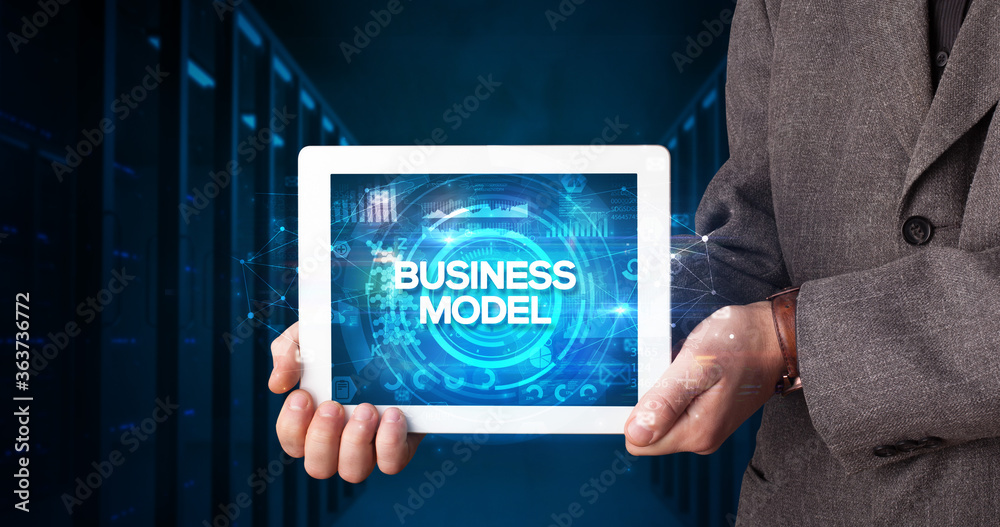 Young business person working on tablet and shows the inscription: BUSINESS MODEL, business concept Young business person working on tablet and shows the inscription: BUSINESS MODEL, business concept