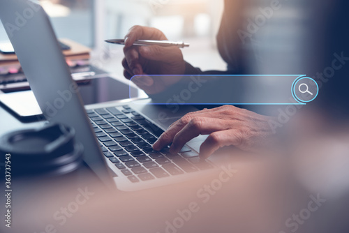 Photos Man searching internet via laptop computer for Search Engine Optimization SEO co