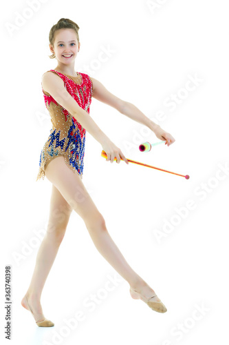 A girl gymnast performs exercises with a mace.