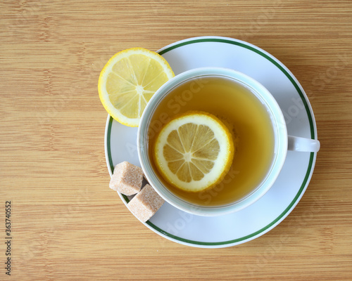 Cup of green tea with slices of lemon and sugar
