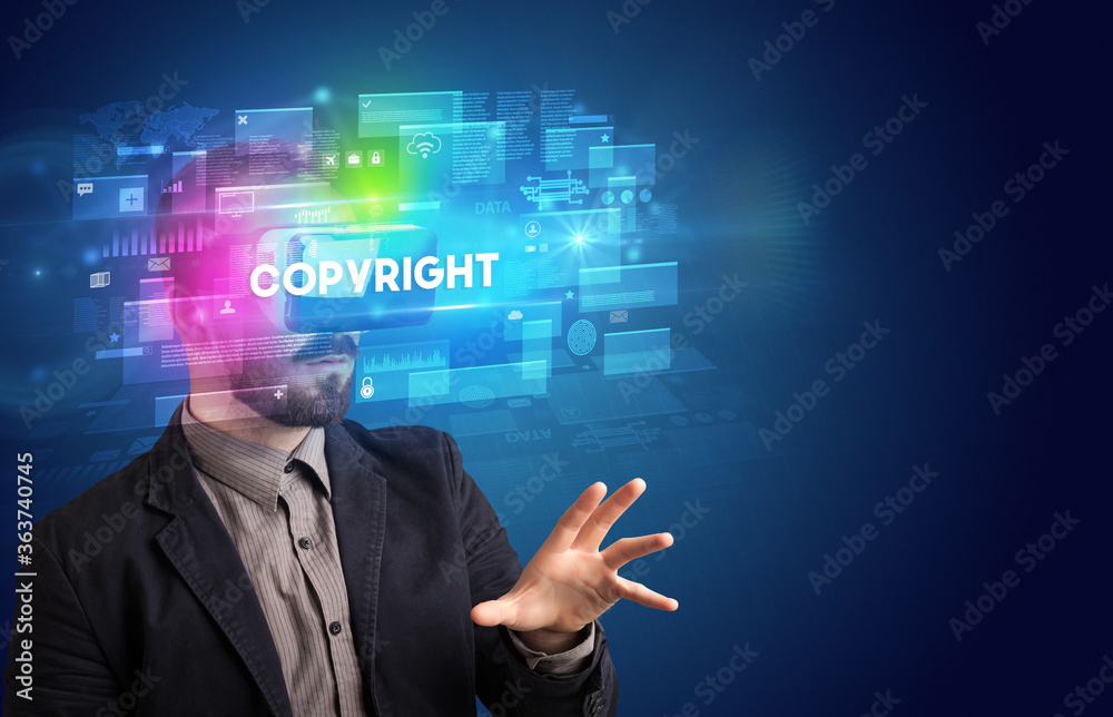 Businessman looking through Virtual Reality glasses with COPYRIGHT inscription, innovative security concept Businessman looking through Virtual Reality glasses with COPYRIGHT inscription, innovative security concept