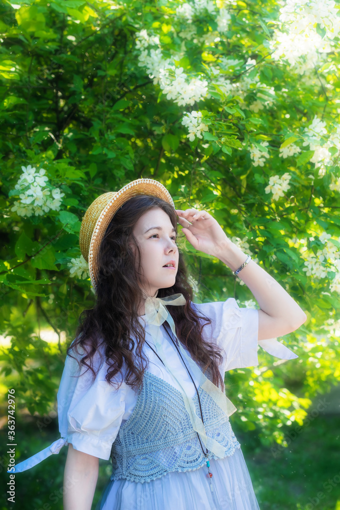 Woman in white dress near blooming apple tree Woman in white dress near blooming apple tree