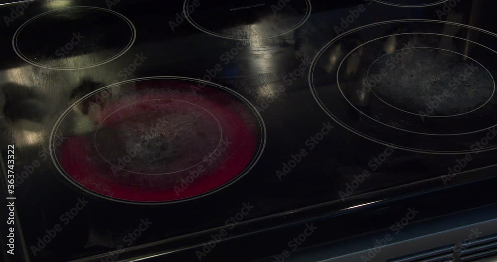 A person using an electric stove cooking a fried egg on a pan with oil A person using an electric stove cooking a fried egg on a pan with oil