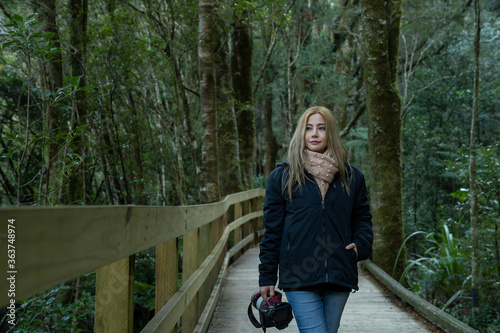 Asian woman looking at view with beautiful scenic of milford sound in fiordland national park new zealand.