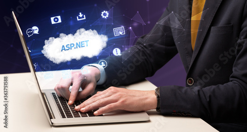 Businessman working on laptop with ASP.NET inscription, modern technology concept
