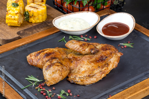 Grilled chicken served on a black slate board