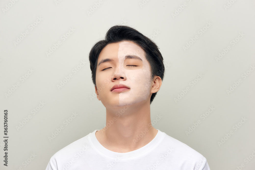 Portrait of a beautiful young man with a facial clay mask, face care treatment. Portrait of a beautiful young man with a facial clay mask, face care treatment.
