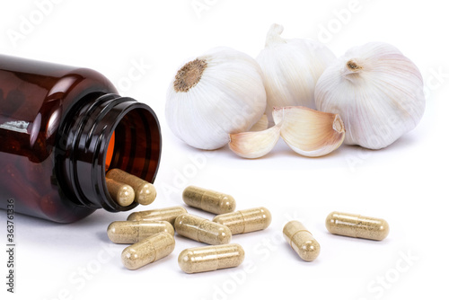 garlic with medicine capsule pills isolated on white. photo