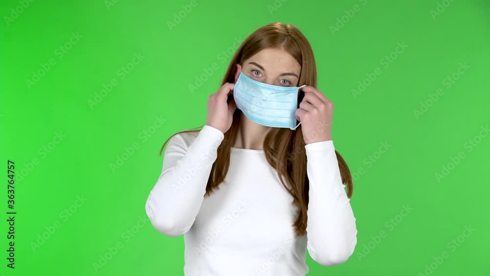 Portrait of pretty young girl puts on medical mask. Portrait of pretty young girl puts on medical mask.