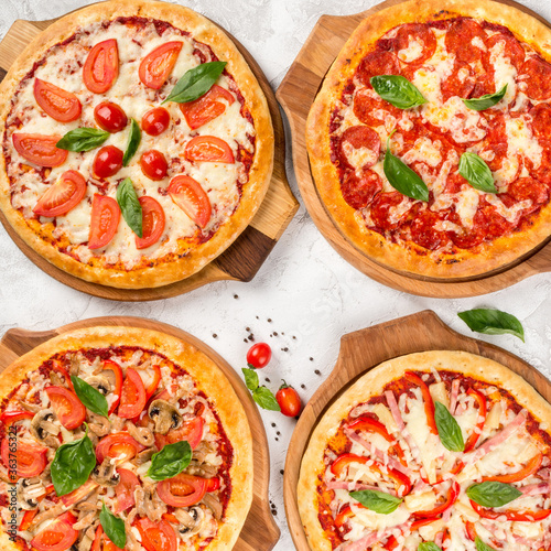 Four types of pizza shot from above on wooden boards