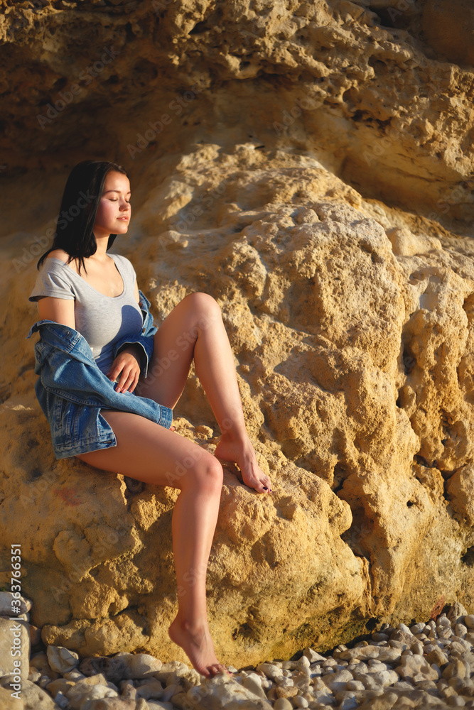 portrait of a woman in a denim jacket on a background of yellow rock portrait of a woman in a denim jacket on a background of yellow rock