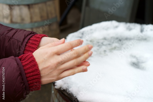 Female hands touching snow in winter