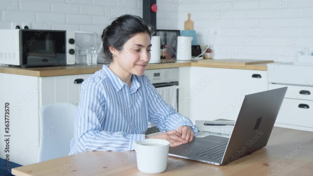 A Cheerful Young Indian Woman Smiles And Communicates Online With Friends On The Computer She Is Sitting At Home A Cheerful Young Indian Woman Smiles And Communicates Online With Friends On The Computer She Is Sitting At Home