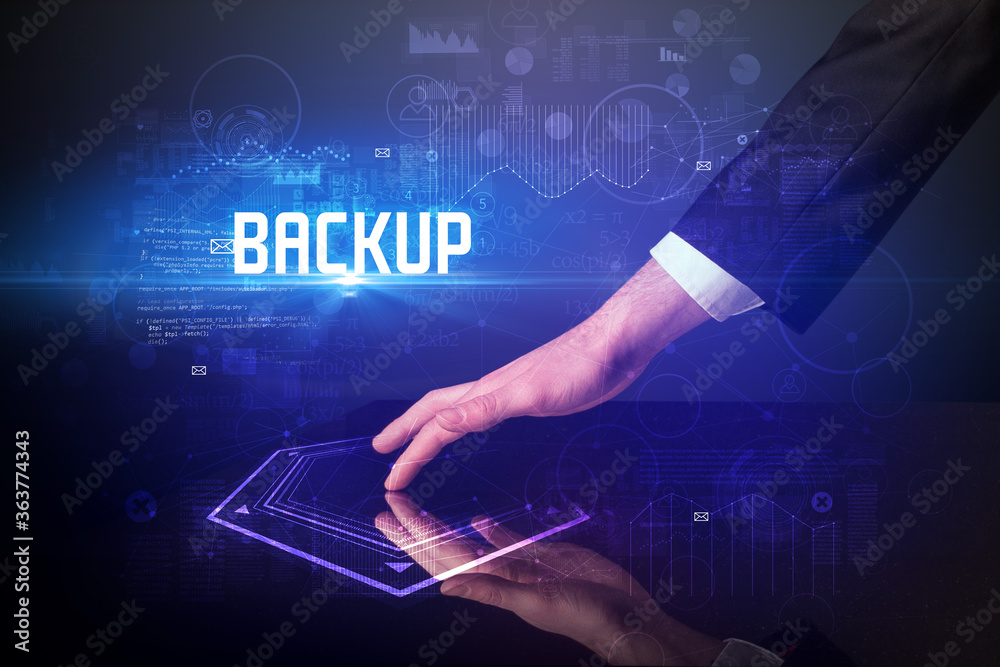 Hand touching digital table with BACKUP inscription, new age security concept Hand touching digital table with BACKUP inscription, new age security concept