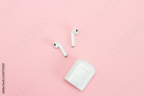 White Wireless headphones with case on pink background