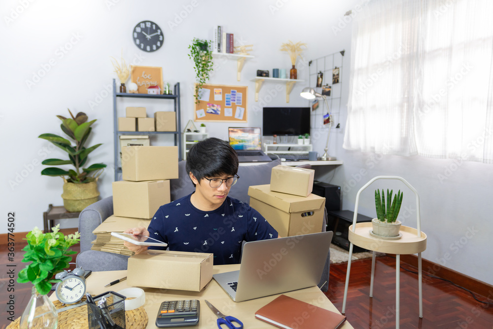 Asian man business owner working with laptop for checking packaging delivery e-commerce online market on purchase orders to customer
Asian man business owner working with laptop for checking packaging delivery e-commerce online market on purchase orders to customer