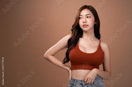 Obraz na plátne Slim body and big breast asian woman looking and arms akimbo, Red crop bralette