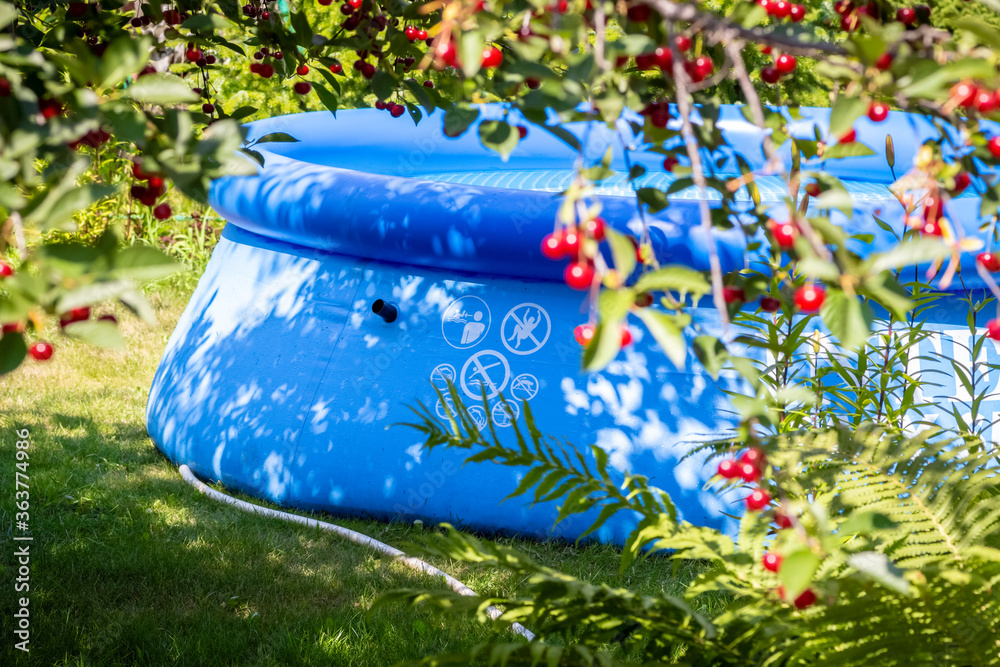 Inflatable blue pool in the backyard of a private house. Inflatable blue pool in the backyard of a private house.
