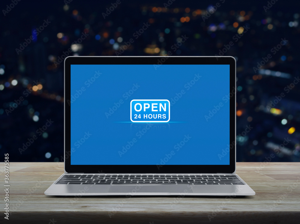 Open 24 hours flat icon with modern laptop computer on wooden table over blur colorful night light office city tower and skyscraper, Business full time service online concept
