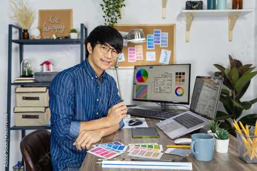 Asian men Architect or graphic designer designing a layout selection swatch samples for coloring screen 