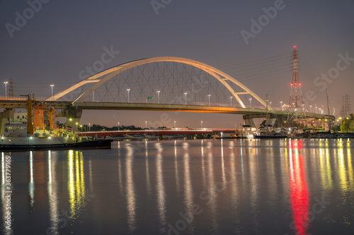水面に浮かぶ新浜寺大橋と工場の光