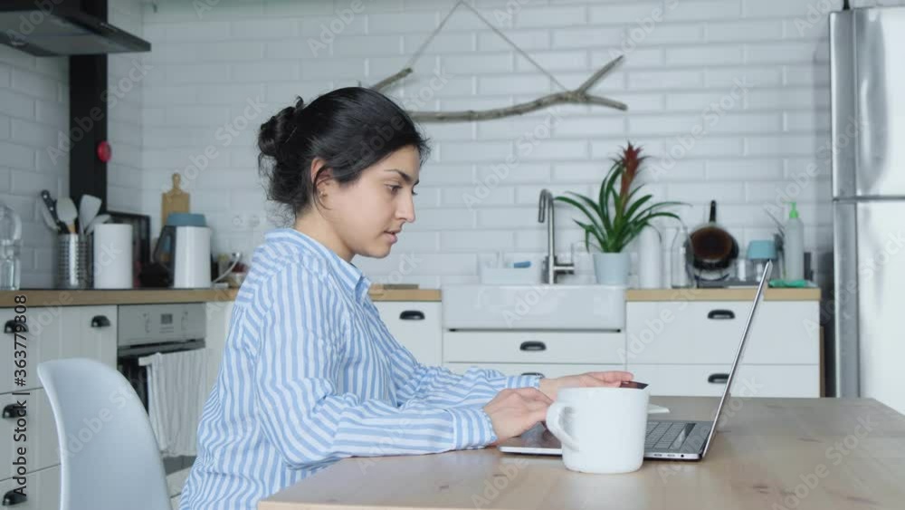 Side view concentrated young indian businesswoman working on computer at office or home, communicating with clients. Focused successful hindu female international company employee busy with project. Side view concentrated young indian businesswoman working on computer at office or home, communicating with clients. Focused successful hindu female international company employee busy with project.