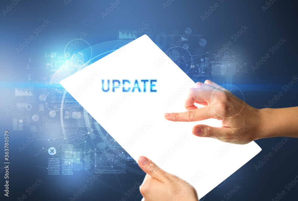 Hand holdig futuristic tablet with UPDATE inscription, new technology concept Hand holdig futuristic tablet with UPDATE inscription, new technology concept