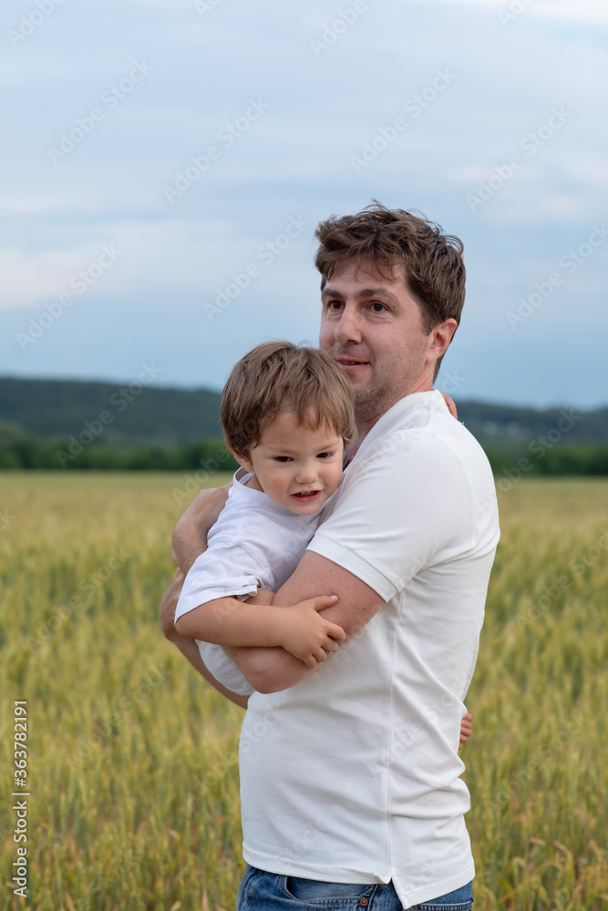 Father and little son walking in the field Father and little son walking in the field