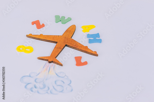 Concept Back to School. Flight of knowledge with airplane and colored letters on the background.