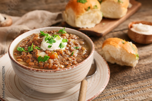 Bowl of tasty lentils soup on table