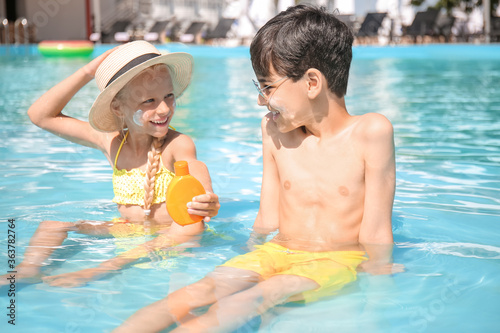 Little children with sun protection cream in swimming pool © Pixel-Shot