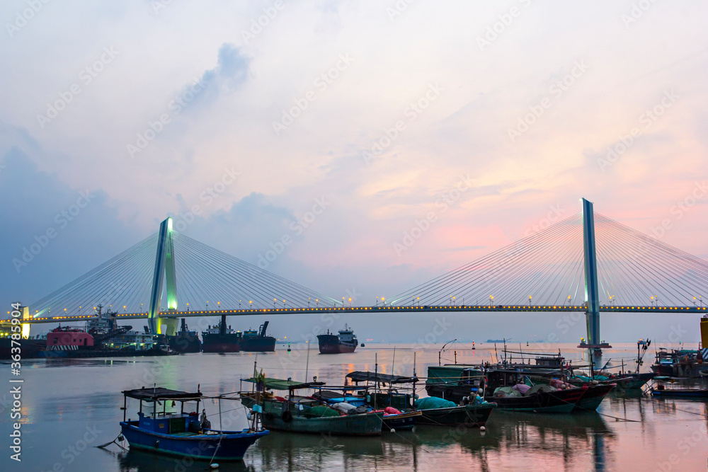 A bridge crosses the sea at sunrise and sunset in hainan, China.