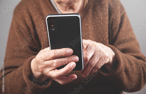 Caucasian elderly woman using smartphone.