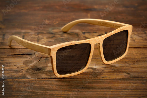 Bright wooden sunglasses on wooden surface